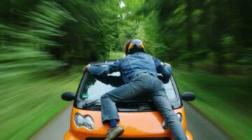 I love this picture of a guy jumping on the front of a smart car.