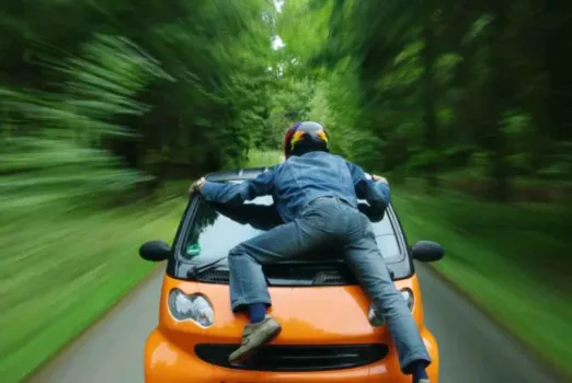 I love this picture of a guy jumping on the front of a smart car.